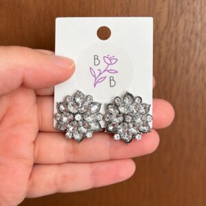 Par de Aretes Fiorella de diseño floral con brillantes transparentes y aleación de tono plateado.